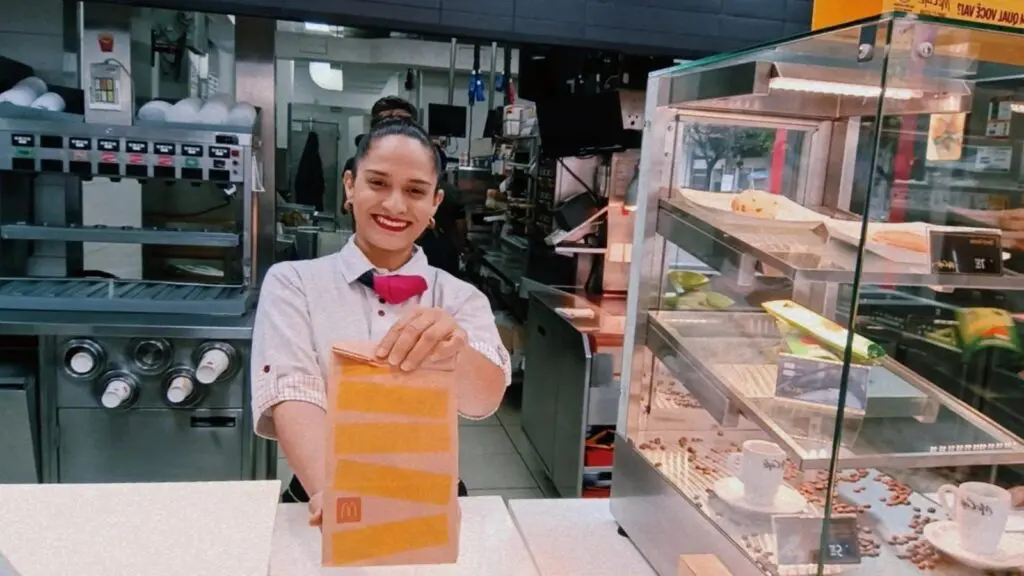 McDonald’s oferece 85 vagas de emprego para nova unidade na Serra Funcionaria entregando um lance ao cliente em uma loja do McDonald’s