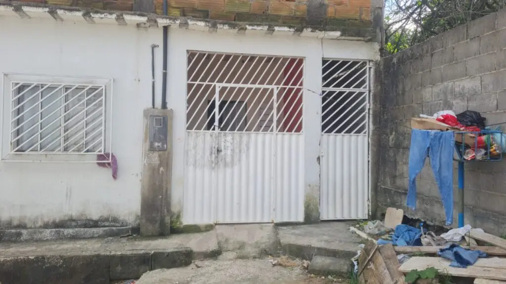 Imagem de uma casa com a fechadura do portão danificada.