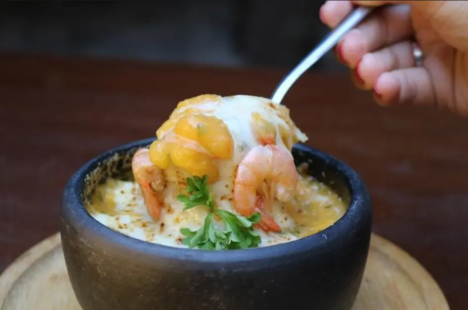 Imagem de uma cumbuca com uma receita com camarões.