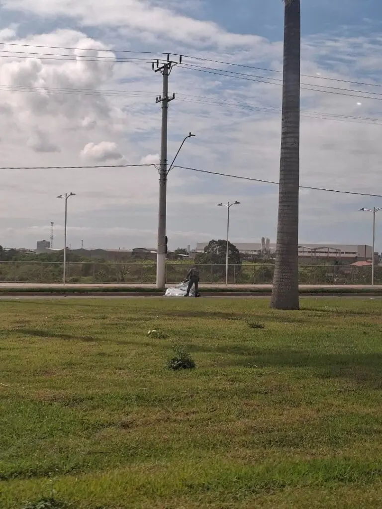 Imagem de um policial militar, ao lado de um corpo coberto.