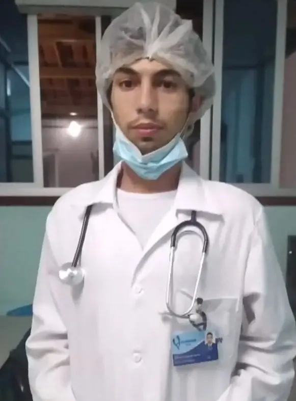 Imagem de um homem (Gabriel Costa de Castro, de 35 anos) usando toca e um jaleco branco usado por profissionais da área da saúde.