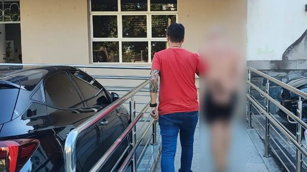 Professor preso na Serra sendo escoltado por policial até a delegacia; PCES aponta ao menos 8 vítimas