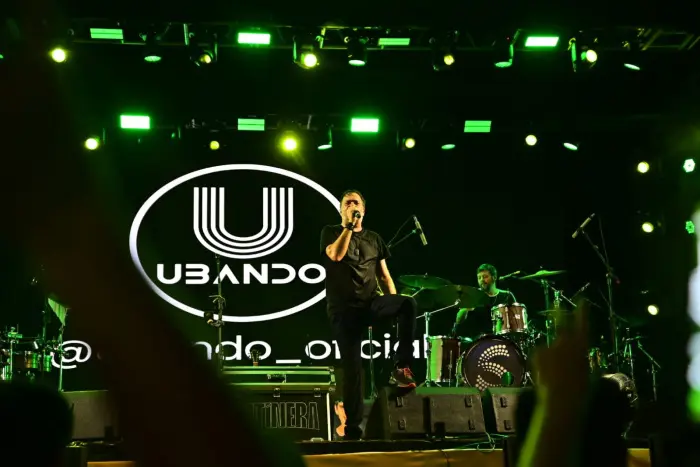 Imagem de um palco com uma banda se apresentando.