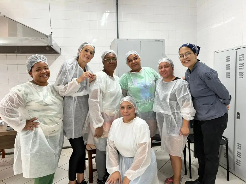 Imagem de um grupo de sete mulheres posando para uma foto durante um curso de fabricação de ovos de Páscoa. 