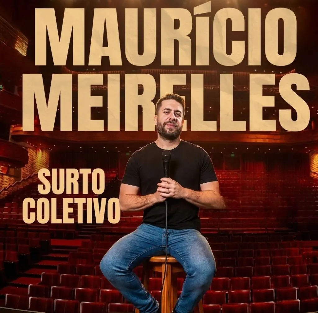 Imagem de um humorista chamado Mauricio Meirelles, sentado, e no fundo um palco.