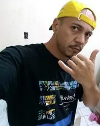 Um homem usando boné, fazendo um sinal com a mão durante uma selfie, (Gideone Ferreira Braga, de 39 anos), procurado pelo crime de homicídio.