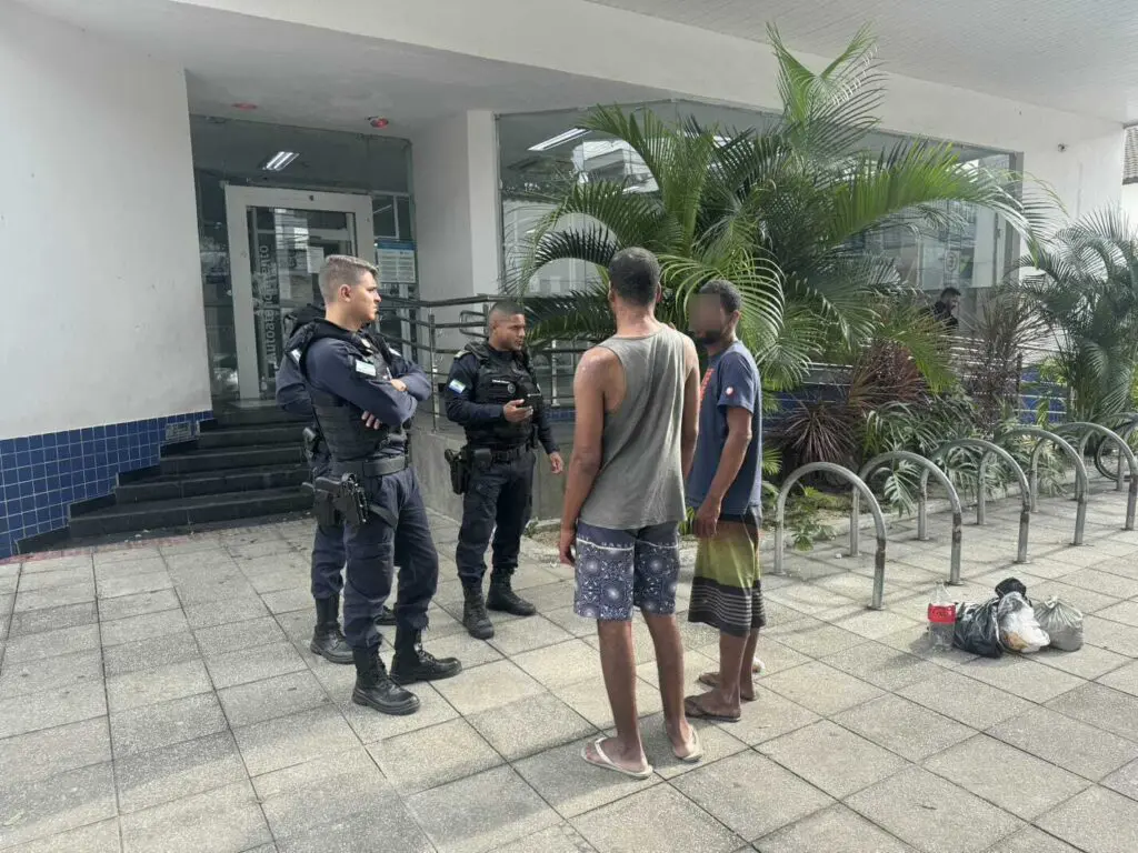 Imagem de uma equipe com 3 agentes da Guarda da Serra, conversando com dois homens em situação de rua.