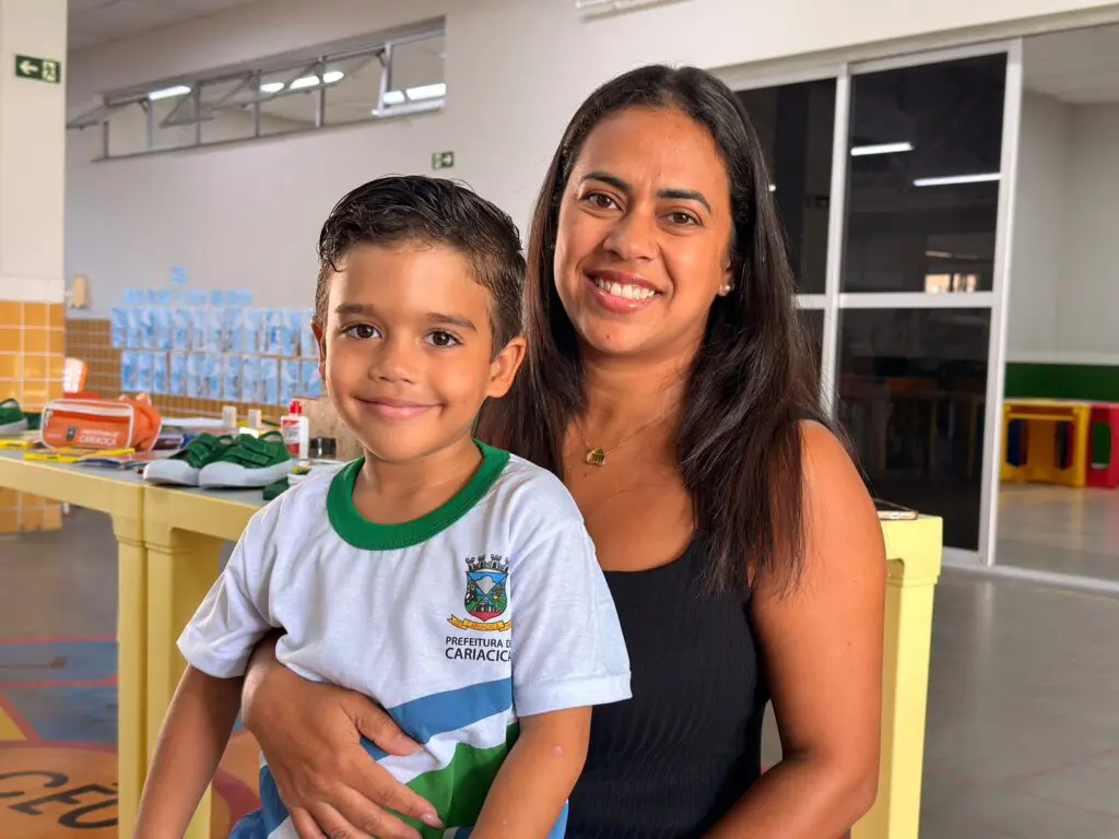 Uma mulher sorridente segurando uma criança em seu colo.