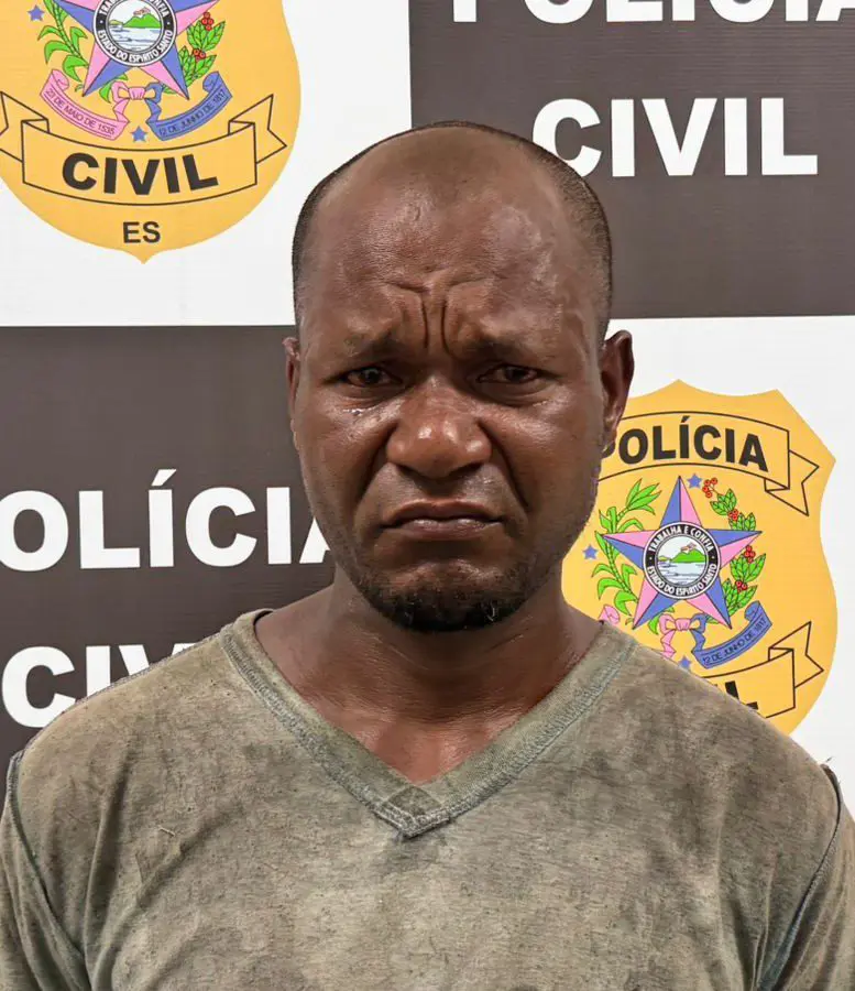 Um homem em frente a uma parede com o emblema e nome da Polícia Civil.