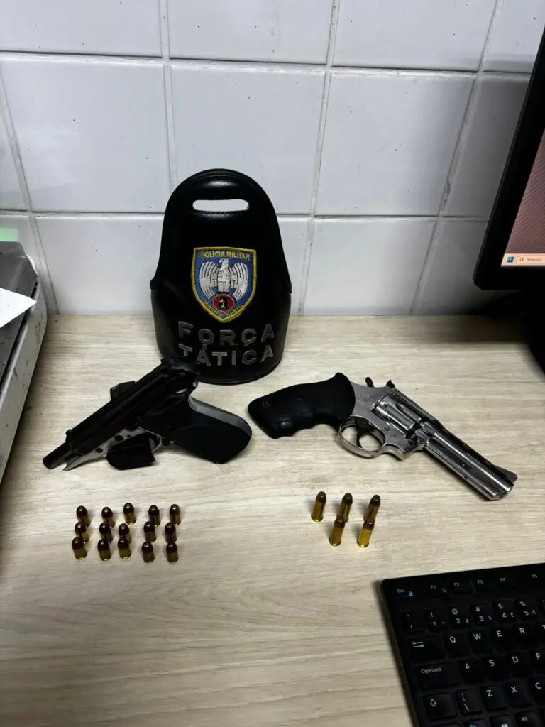 Sobre uma mesa: uma pistola calibre .380, um revólver calibre .38, além de 20 munições.
