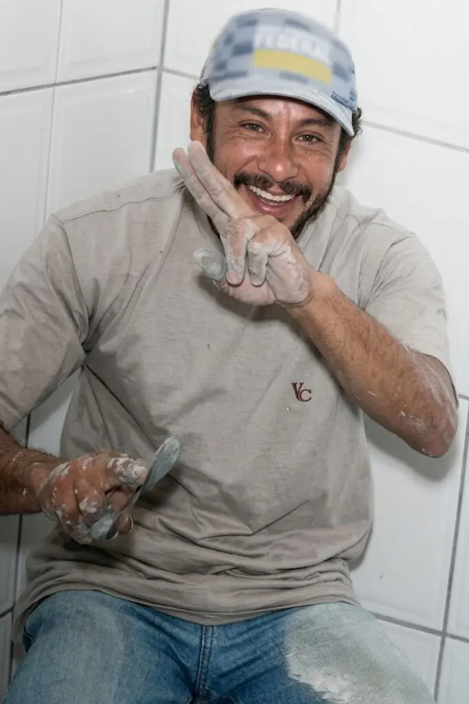Imagem de um homem de boné (Wilson Couto do Nascimento, de 51 anos) sorrindo, fazendo o gesto de vitória com uma das mãos.