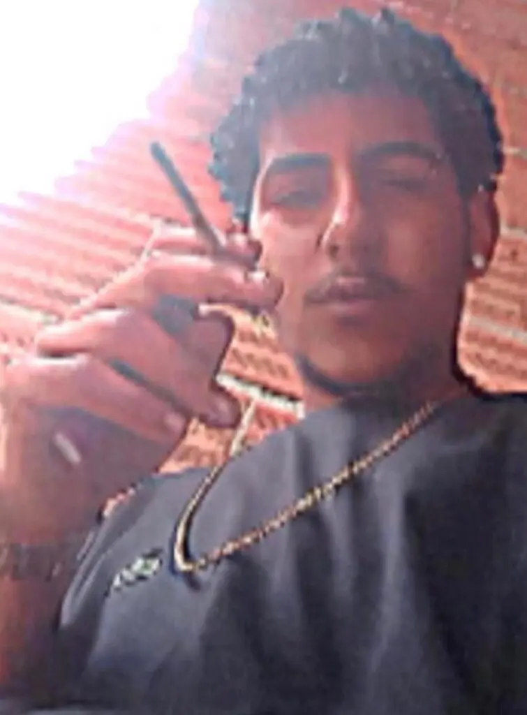 Foto de um sujeito (Felipe Pereira da Silva, de 21 anos) segurando um cigarro.