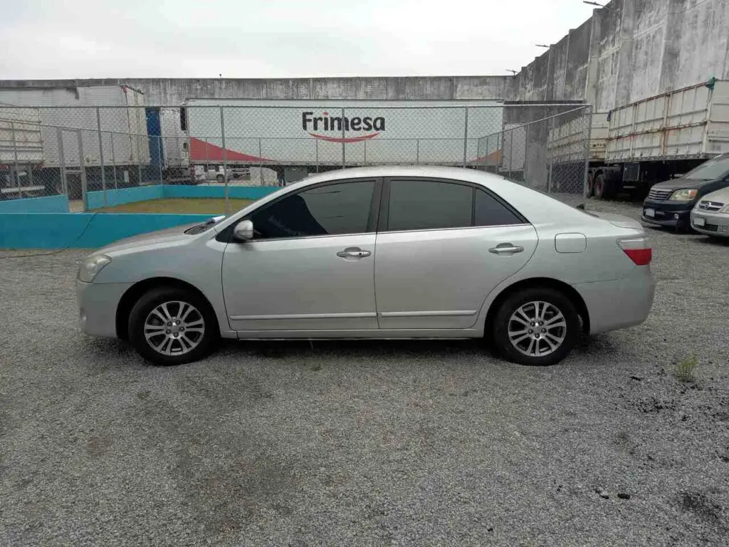 Imagem de um automóvel. Toyota Premio 2007, estacionado em um pátio.
