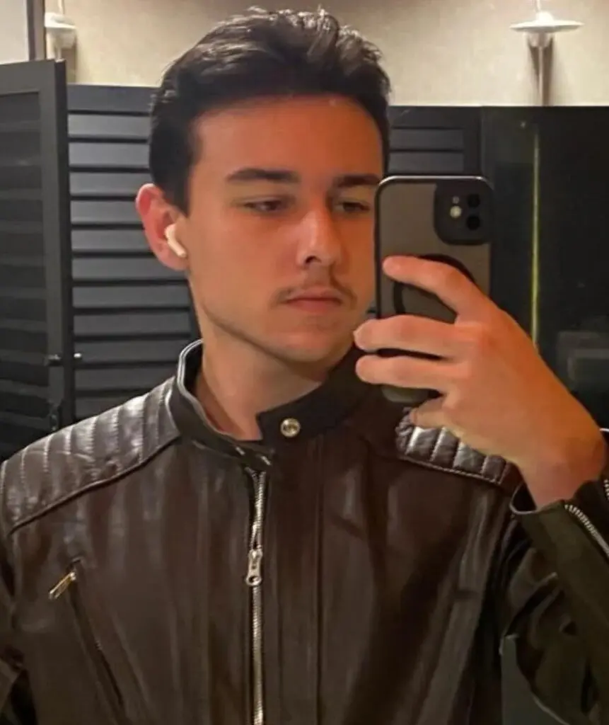 Foto de um jovem de 19 anos. (Rafael Andreoli Brunhara), segurando um celular durante uma selfie.