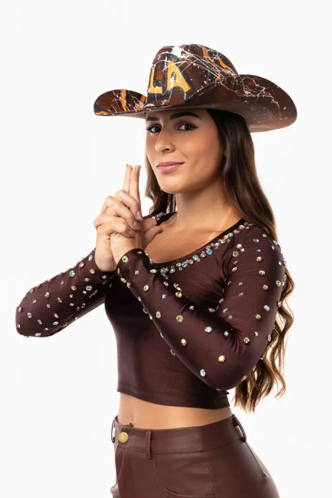 Foto da cantora Luiza Andrade usando chapéu e posando para uma foto.