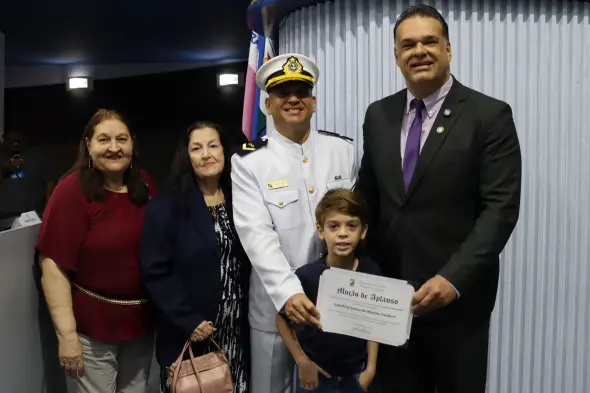 Foto do vereador Leonardo Monjardim ao lado do suboficial da Marinha Leonardo Bitarães Calobrisi, reunido com duas mulheres e uma criança.