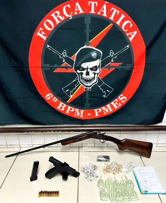 Sobre uma mesa, 70 pinos de cocaína, 92 pedras de crack, 34 porções de haxixe, um pedaço de haxixe, uma pistola calibre 9mm, uma espingarda calibre 36, dois carregadores de pistola calibre 9mm, 24 munições calibre 9mm, além de um caderno com anotações relacionadas ao tráfico. E pendurada na parede uma bandeira da Força Tática do 6° Batalhão da PM, com o desenho de uma caveira de boina, com dois fuzis cruzados atrás da caveira.