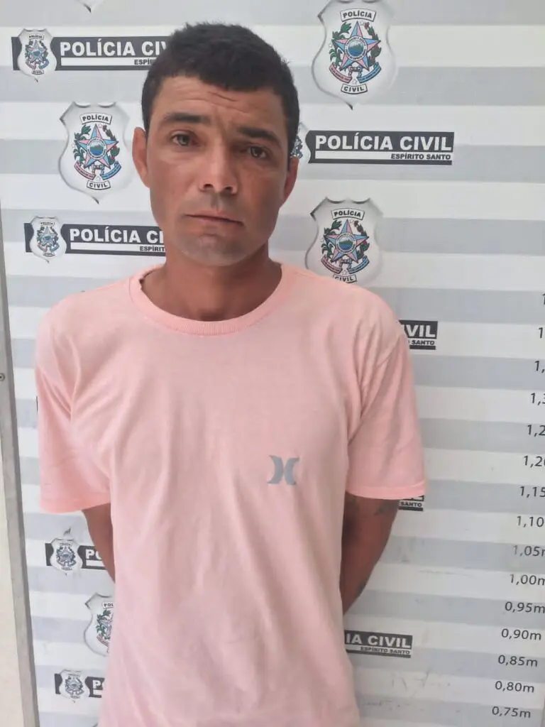 Um homem (Wellington da Cruz Santos, vulgo “Bilu”, de 34 anos) em frente a uma parede com marcações de altura, como as que a Polícia Civil utiliza após a prisão de um suspeito.
