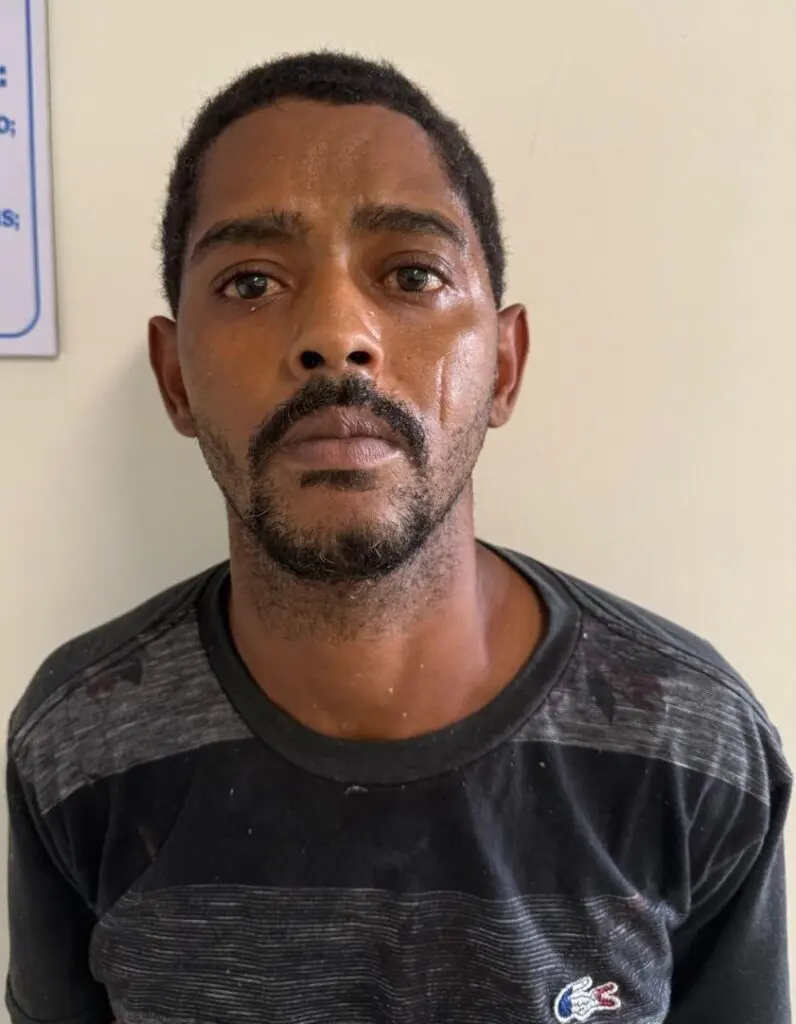 Foto de um homem (Roberto Fernandes da Silva) com os braços para trás após ser preso.