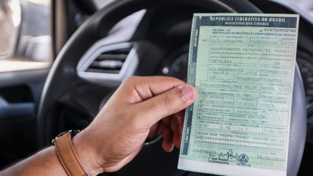 Confira a lista de carros que vão estar livres de pagar o IPVA em 2023, no ES Foto de uma pessoa segurando o seu IPVA dentro do carro