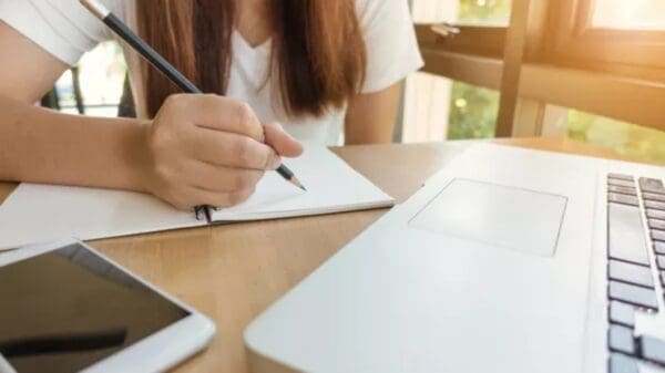 Uma estudante escrevendo em uma folha de papel