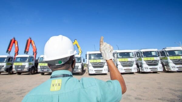 Imagem de um funcionário do grupo vix, juntamente com os caminhões da empresa