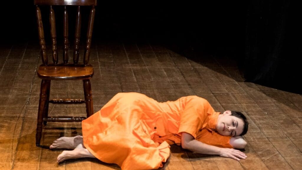 Foto ilustrativa da atriz caída próxima a uma cadeira