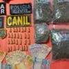 Dinheiro, sacos de maconha, pinos de cocaína sobre a uma mesa vermelha da Policia Militar