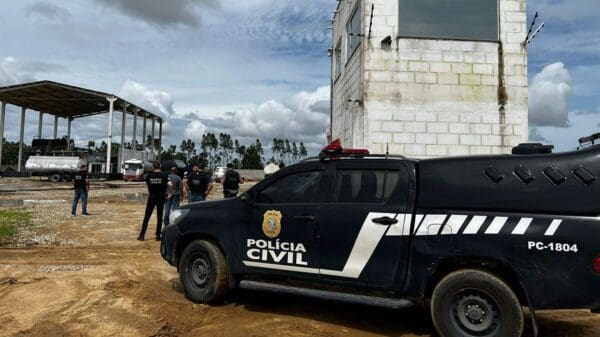 Viatura da Policia Civil do Espirito Santo estacionada em patio de empresa de transporte de combustíveis com agentes da Policia Civil ao lado