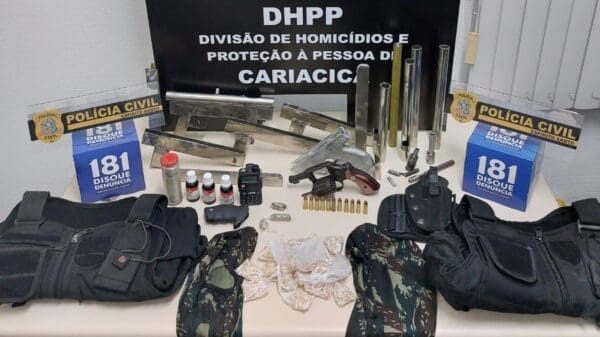 Sobre a mesa da Policia Civil armas, coletes, drogas e materiais para construção de armas