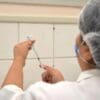Enfermeira preparando seringa com dose de Vacina