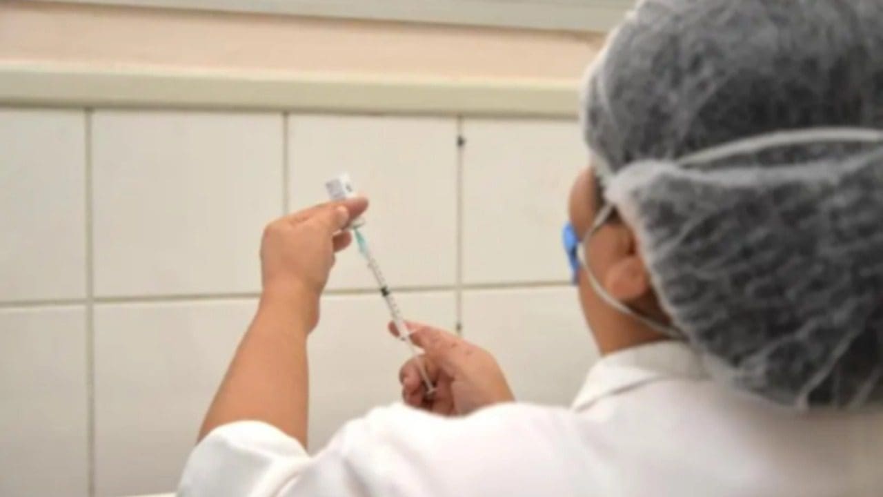 Enfermeira preparando seringa com dose de Vacina