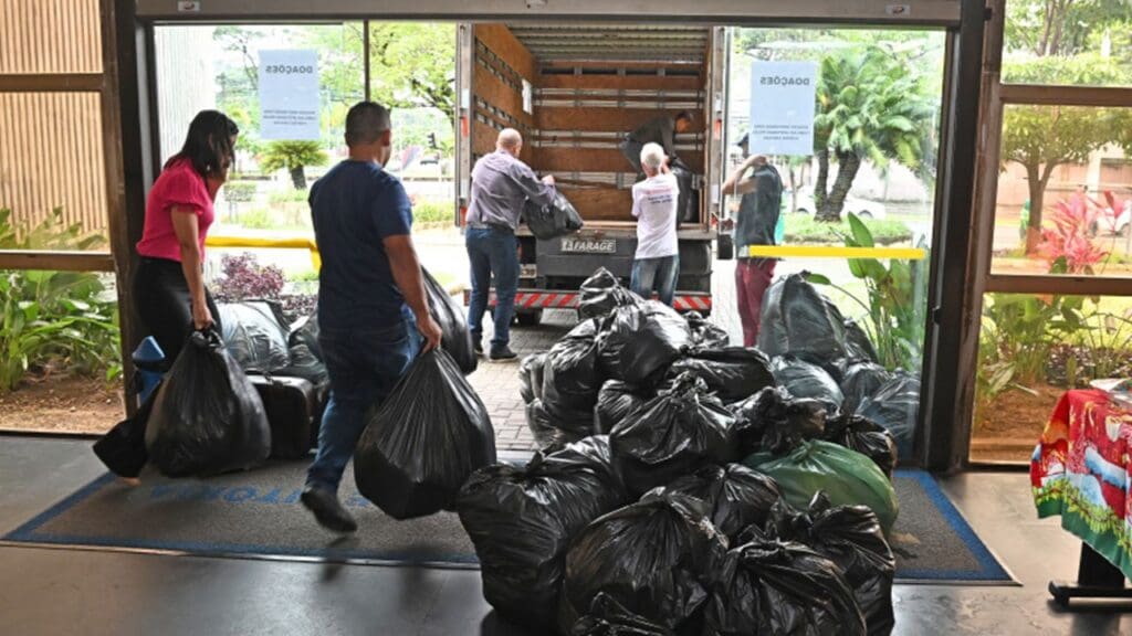 Funcionários no saguão da Prefeitura de Vitória carregando as doações para um caminhão