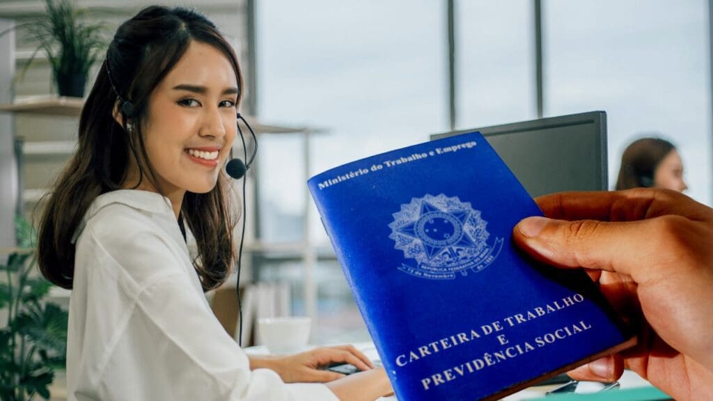 Atendente sorridente em guichê, recebendo a carteira de trabalho de uma pessoa