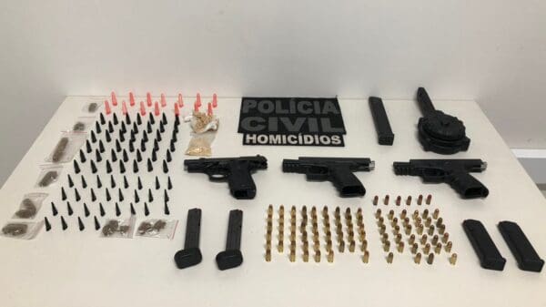 Sobre a mesa da Polícia Civil de Vila Velha, três pistolas, dezenas de munições e pinos de cocaína