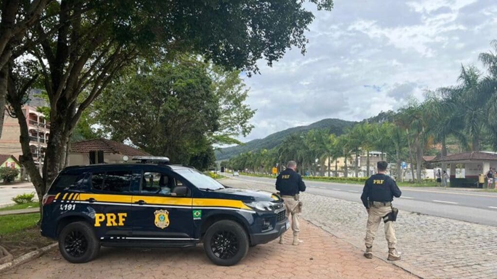 Equipe da Polícia Federal Rodoviária com viatura estacionada em um acostamento de uma Rodovia no ES fazendo fiscalizações