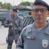 Sargento da 14ª Cia Ind. Mauricio Sousa, relatando a prisão de um traficante e logo atras dois Militares em pé ao lado da viatura segurando sus armas
