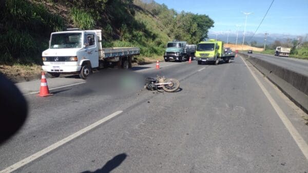 Foto do motociclista vítima de atropelamento caído no asfalto, no momento do acidente