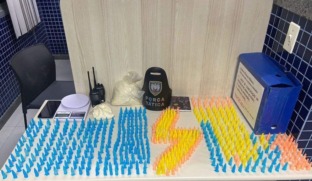 Sobre a mesa da delegacia mais de 500 pinos de cocaína, rádios comunicadores, duas sacolas com cocaína, uma balança de precisão e um celular