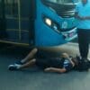 Homem caído no asfalto ao lado do ônibus