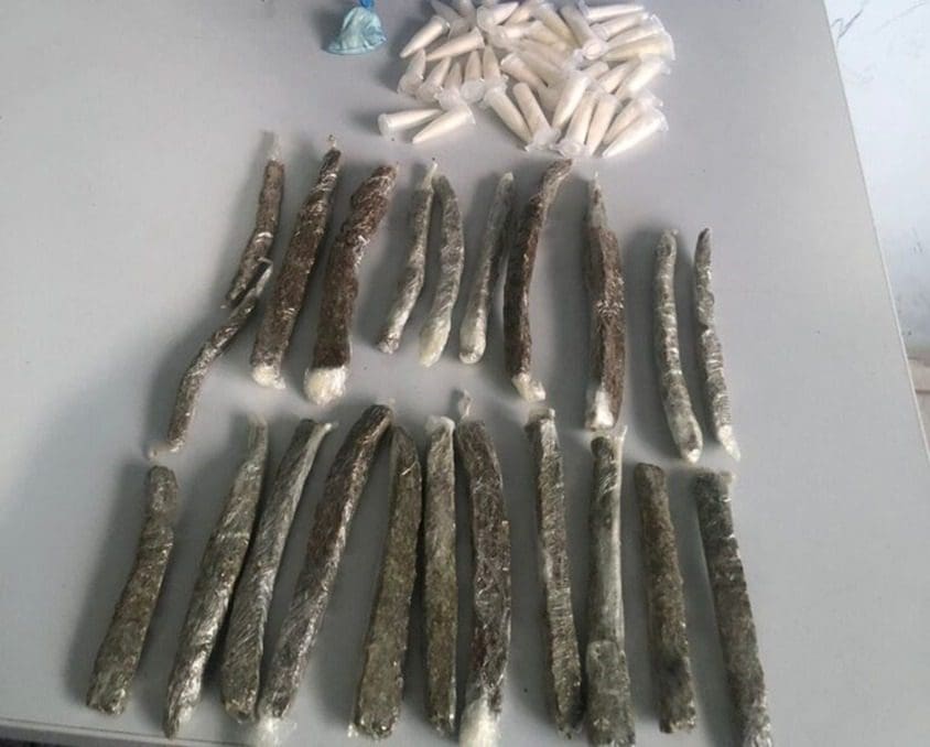 Sobre uma mesa branca na Delegacia Regional de Serra, 23 buchas de maconha, 35 pinos de cocaína e 1 papelote de substância similar a cocaína