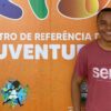 Jiberlandio Miranda Santana novo gerente da Subsecretaria de Políticas para as Juventudes em frente a um muro do Centro de referência das Juventudes