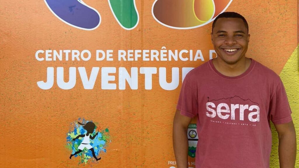 Jiberlandio Miranda Santana novo gerente da Subsecretaria de Políticas para as Juventudes em frente a um muro do Centro de referência das Juventudes