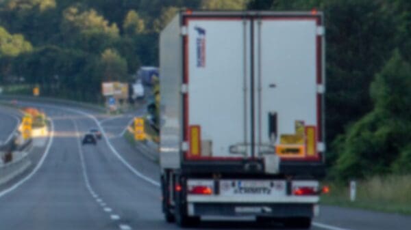 Imagem de um caminhão vista de trás, trafegando em uma estrada com efeito de desfoque