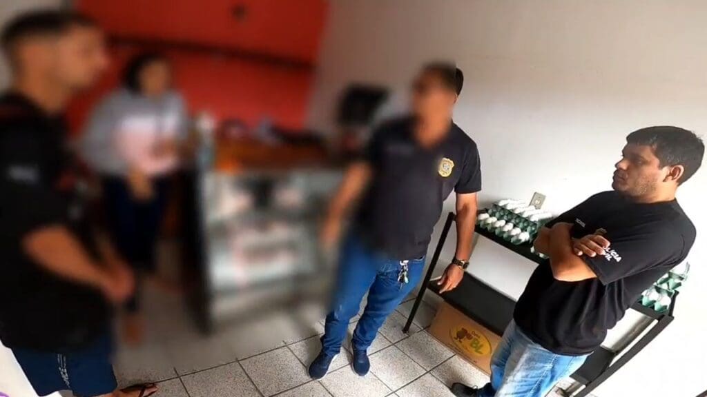 imagem de dois Policiais Civis, dentro de um estabelecimento conversando com um homem e uma mulher que era vitima de agressões