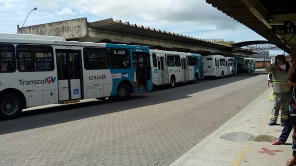 Foto: Terminal Carapina, 4 ônibus do Sistema Transcol estacionados nas plataformas, com passageiros entrando nos ônibus