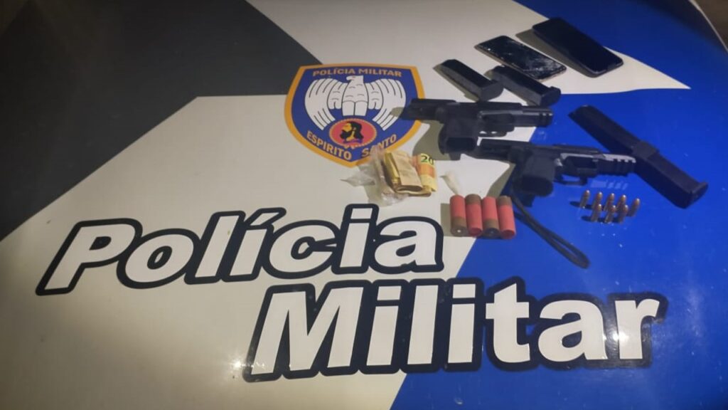 Sobre o capo de uma viatura da PM um carregador de pistola .40, uma Taurus calibre .40 e uma pistola Arex Delta calibre 9mm com um carregador alongado de alta capacidade, 04 munições calibre 12 e outras 07 munições calibre 9mm.