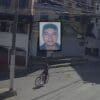Homem descendo uma rua íngreme de bicicleta e um pouco acima a foto do rosto do homem, que se acidentou e veio a óbito no acidente
