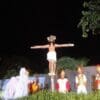 Foto da encenação da Paixão de Cristo, duas pessoas sendo crucificadas uma delas representa Jesus e envolta da crus em que Jesus está soldados romanos e seguidores