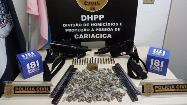 uma arma de fogo, dois carregadores, sobre uma mesa branca 376 buchas de maconha e 69 munições calibre 9mm.